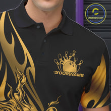Load image into Gallery viewer, Close-up view of the left chest area of a black polo shirt showing a golden metal tribal flame bowling ball and pins design detail.