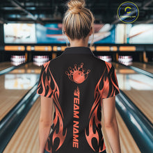 Load image into Gallery viewer, Female model back view in bowling lane wearing black polo shirt showcasing red gradient tribal flame bowling ball striking pins in vivid motion design.