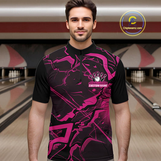 Male model wearing a black and pink quarter-zip in a bowling center featuring bold angular geometric artwork.