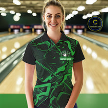 Load image into Gallery viewer, Female model wearing a black and green bowling polo in a bowling lane with cracked geometric artwork.