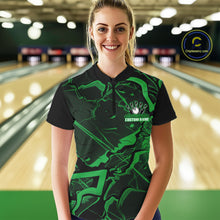 Load image into Gallery viewer, Female model wearing a black and green bowling quarter-zip in a bowling lane featuring sharp geometric lines and cracked pattern artwork.