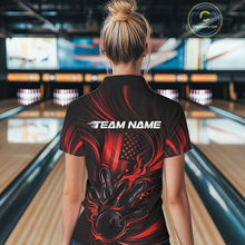 Load image into Gallery viewer, Back view of a female model in a bowling center wearing a black and red polo shirt featuring a flaming bowling strike motif and flag-inspired artwork.