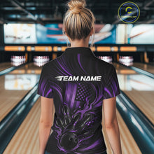 Load image into Gallery viewer, Back view of a female model in a bowling venue wearing a black and purple polo shirt featuring a flaming bowling strike and flag-inspired artwork.