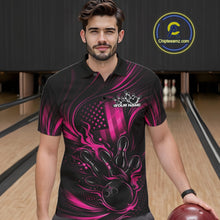 Load image into Gallery viewer, Male model at a bowling lane wearing a black and pink polo shirt with fiery bowling strike artwork and patriotic flag accents.