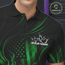 Load image into Gallery viewer, Close-up of a black and green bowling polo shirt left chest showing patriotic flames around a bowling ball striking pins with distressed flag design.
