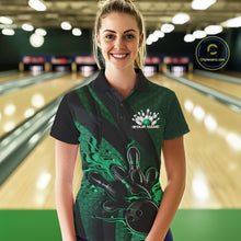Load image into Gallery viewer, Female model wearing a black and green bowling polo shirt at a bowling lane with fiery bowling action artwork and geometric stripe details.