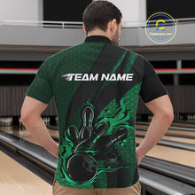 Load image into Gallery viewer, Front view of a male model in a bowling alley wearing a black and green quarter-zip shirt featuring a bowling strike graphic with geometric details.