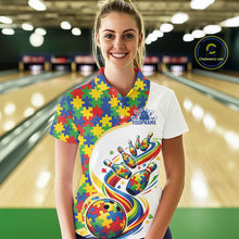 Load image into Gallery viewer, Female model at a bowling lane wearing a white polo shirt, front view showing colorful autism-themed bowling strikes and puzzle graphics