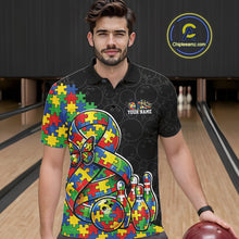 Load image into Gallery viewer, Male model in a bowling lane wearing a black polo shirt, front view featuring autism ribbon puzzle design, butterfly, and bowling strike artwork