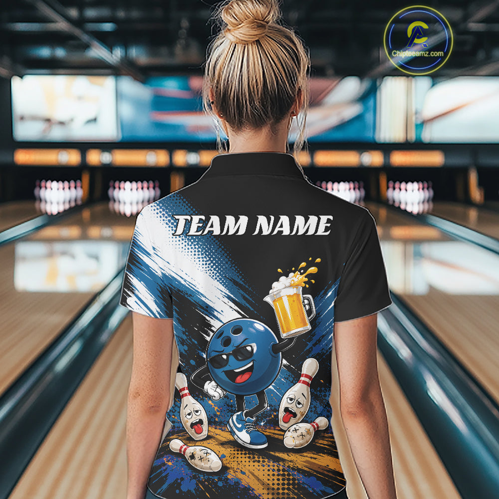 A woman viewed from behind wearing a black short-sleeve bowling-themed polo shirt with a colorful back graphic featuring a cartoon bowling ball, pins, and a beer mug, with the text 'TEAM NAME' across the upper back. The background shows a blurred bowling alley interior.