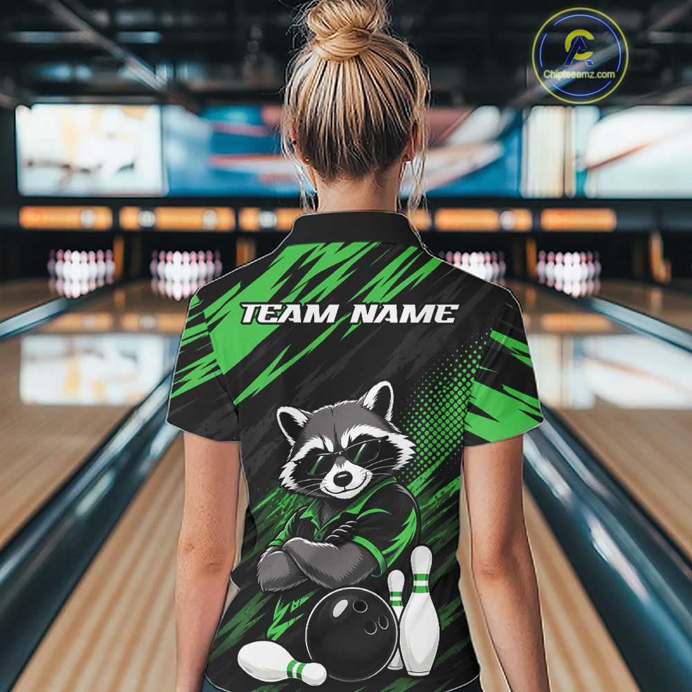 A woman viewed from behind wearing a custom bowling qurater zip shirt with a raccoon graphic and 'TEAM NAME' text, standing in a bowling alley.