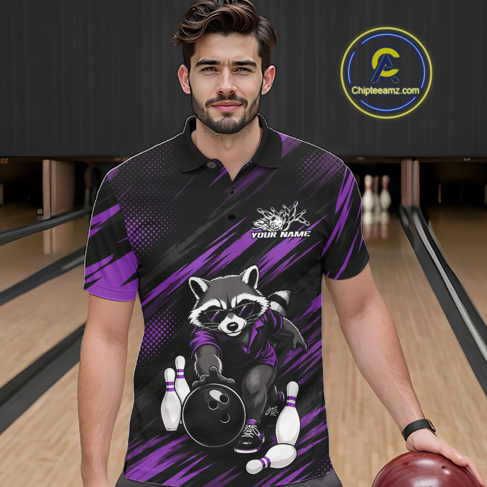 A man wearing a custom bowling-themed polo shirt with a raccoon graphic, standing in a bowling alley. The shirt features a black and purple pattern with a cartoon raccoon holding a bowling ball and pins.