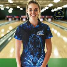 Load image into Gallery viewer, Front view of a female model in a bowling lane wearing a black polo shirt with glowing blue electric panther and dynamic bowling strike visuals.