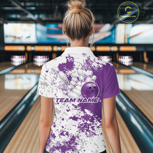 Load image into Gallery viewer, Back view female model in bowling lane wearing white polo with purple and white splatter background, relaxed pose in bowling venue