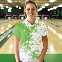 Load image into Gallery viewer, Female model front view in bowling lane wearing white polo shirt with green and white splatter pattern, sporty casual bowling venue scene