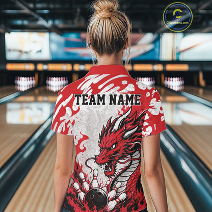 Person wearing a red and white bowling shirt with a dragon design in a bowling alley.