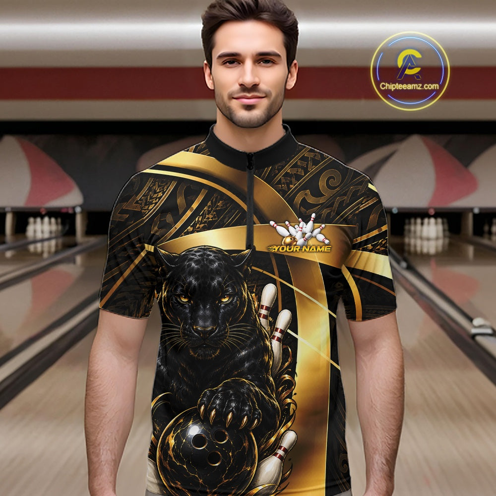 A man wearing a custom bowling-themed short-sleeve shirt with a black and gold design featuring a panther and bowling pins, set against a blurred bowling alley background.
