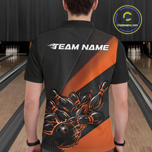 Load image into Gallery viewer, Male model seen from the back in a bowling lane wearing a black and orange polo shirt featuring a flame bowling ball striking pins in a powerful sports motion design.