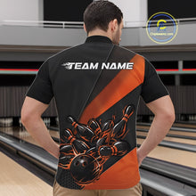 Load image into Gallery viewer, At the bowling lane, front view of a male model wearing a black and orange quarter zip featuring a flaming bowling strike scene with pins scattering in motion.