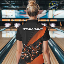 Load image into Gallery viewer, Back view female model inside bowling alley wearing black and orange quarter zip shirt with flame bowling action graphics