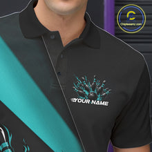 Load image into Gallery viewer, Close-up view of the left chest area of a black and turquoise blue bowling polo shirt showing a flame bowling ball and pins design detail.