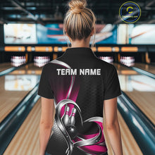 Load image into Gallery viewer, Back view of a female model in a bowling lane wearing a black and pink quarter zip shirt, displaying a honeycomb pattern with a heart-shaped motif around a bowling ball and pins.