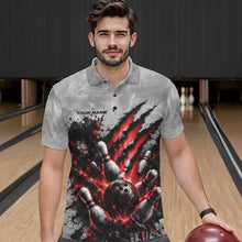 Load image into Gallery viewer, Front view of a male model wearing a gray bowling polo shirt featuring a dramatic red bowling ball and pins graphic with claw-mark artwork in a bowling lane.