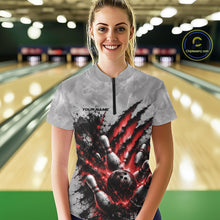 Load image into Gallery viewer, Front view of a female model wearing a gray bowling quarter zip shirt featuring a dramatic red bowling ball and pins graphic with claw-mark artwork in a bowling lane.