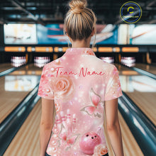 Load image into Gallery viewer, Back view of a female model in a bowling alley wearing a bowling polo shirt showcasing glitter butterfly graphics, diamonds, and bowling artwork.