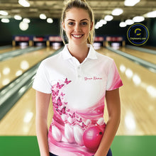 Load image into Gallery viewer, Female model in a white and pink bowling polo shirt featuring butterfly accents and bowling graphics inside a bowling alley.