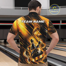 Load image into Gallery viewer, Male model wearing a bowling quarter zip shirt featuring a black and gold bowling ball striking pins with flowing metallic ribbon accents, shown from the front in a bowling lane.