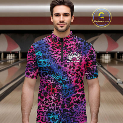 Man in a bowling alley wearing a blue, purple, pink, and black leopard-print bowling quarter zip shirt with “Your Name” and a bowling pins graphic on the chest.
