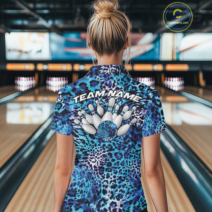 Back view of a woman standing at a bowling alley, wearing a gold, brown, and black leopard-print bowling polo with “Team Name” and bowling pins on the back.
