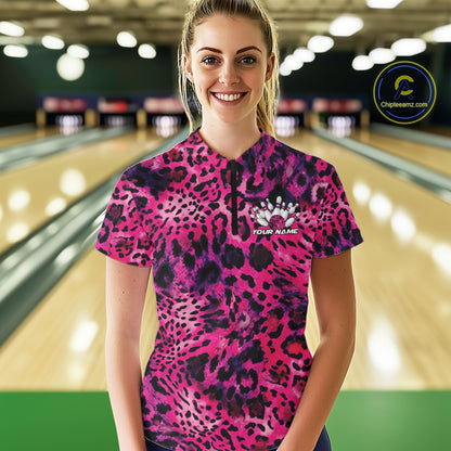 Smiling woman in a bowling alley wearing a pink, purple, and black leopard-print bowling quarter zip shirt with “Your Name” and a bowling pins graphic on the chest.