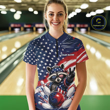 Load image into Gallery viewer, Front view of a female model wearing a bowling quarter zip shirt featuring a patriotic raccoon flashing a peace sign with a red, white, and blue bowling ball crashing through pins beneath a flowing American flag in a bowling lane.