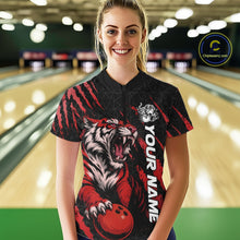Load image into Gallery viewer, Front view of a female model in a bowling lane wearing a black and red bowling quarter-zip shirt showcasing a roaring tiger holding a red bowling ball with matching red claw-stripe artwork and a geometric background pattern.