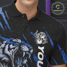 Load image into Gallery viewer, Close-up view of the left chest on a black and mid blue bowling polo shirt featuring a roaring tiger holding a mid blue bowling ball with coordinated claw-stripe graphics and a geometric background pattern.