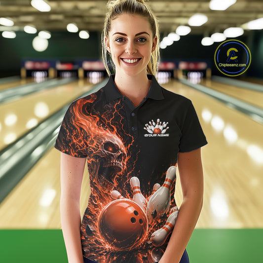 Front view of a female model in a bowling alley wearing a black bowling polo with an orange flaming skull, lightning, bowling pins, and a custom name.

