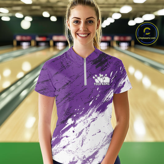 Woman wearing a purple and white bowling shirt with a personalized name on a bowling alley.