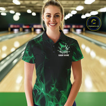 Load image into Gallery viewer, Female model at a bowling lane wearing a black and green bowling polo shirt with scattered bowling pins and fiery bowling action graphics.