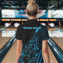 Load image into Gallery viewer, Back view of a female model in a bowling center wearing a black polo shirt featuring a blue flaming bowling ball knocking down pins.