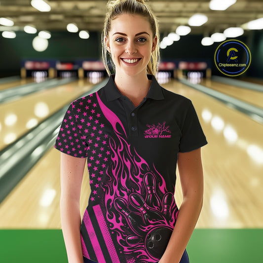 Female model wearing a black bowling polo shirt at a bowling lane with pink flame bowling strike artwork and patriotic styling.