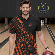 Load image into Gallery viewer, Close-up of the left chest area on a black bowling polo shirt featuring an orange flaming bowling ball striking pins with flag-inspired accents.