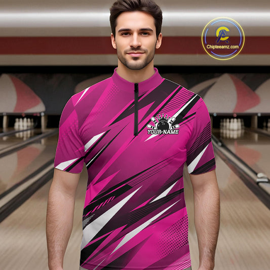 Man wearing a pink bowling shirt with a logo in a bowling alley.