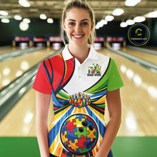 Load image into Gallery viewer, Female model in a bowling alley wearing a white polo shirt, front view highlighting autism bowling lane illustration with colorful puzzle graphics