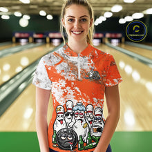 Load image into Gallery viewer, Front view of a female model in a bowling lane wearing an orange and white grunge splatter bowling quarter-zip shirt with playful bowling pins and beer bottle graphics.