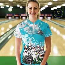 Load image into Gallery viewer, Front view of a female model in a bowling lane wearing a white quarter-zip shirt with turquoise blue and white grunge splatter design and playful bowling-themed illustration.