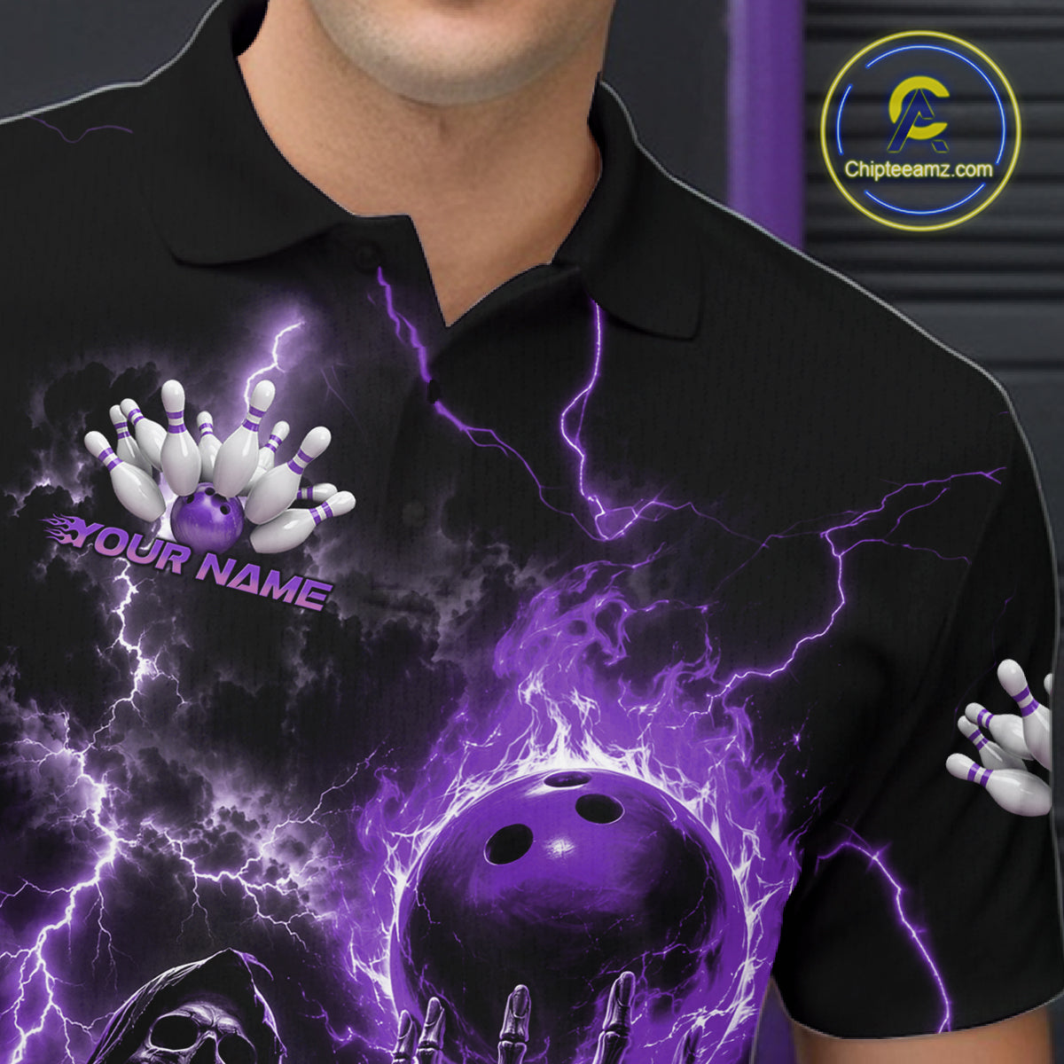 A close-up of a person wearing a black short-sleeve polo shirt with a vivid purple and white bowling-themed graphic print featuring lightning effects, bowling pins, a bowling ball, and the text '#YOUR NAME'.