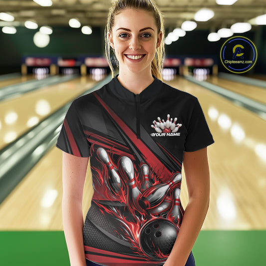Female model in a bowling lane wearing a black quarter-zip shirt, red flame bowling ball hitting pins with bold geometric stripe styling.