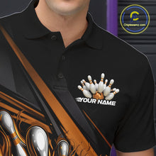Load image into Gallery viewer, Close-up left chest detail of black bowling polo shirt featuring gold flame bowling ball and pins emblem with geometric stripe accents